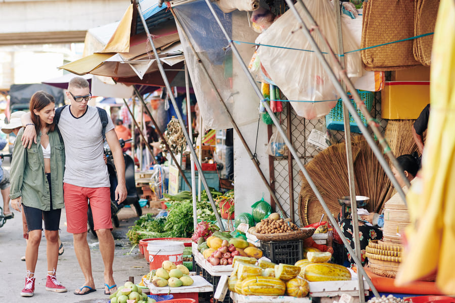 pareja de turistas caminando en mercado chino