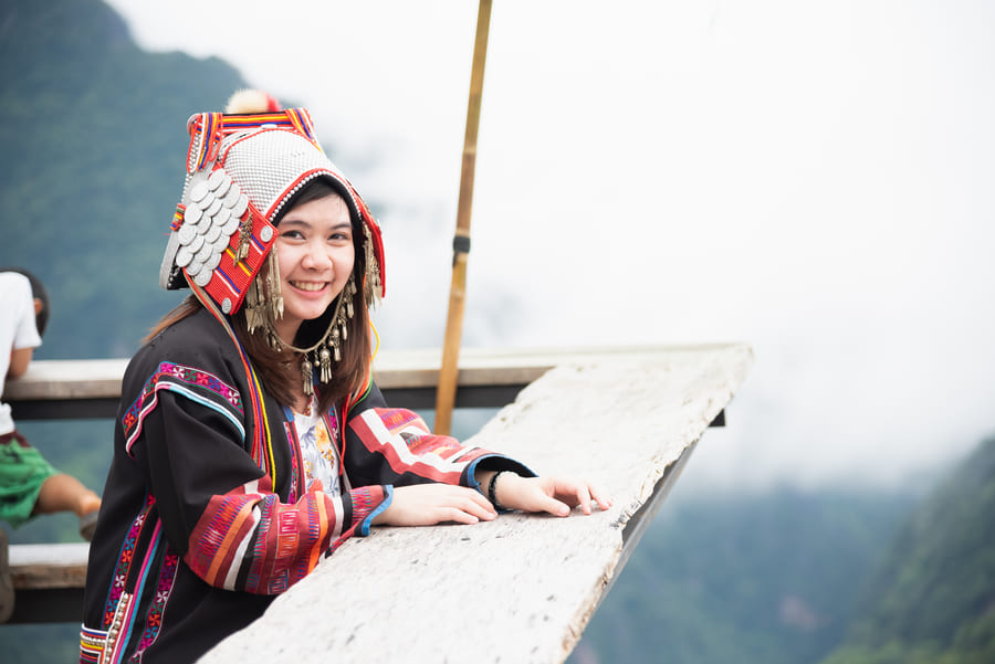 mujer en mirador en yunnan china, vestida conropa tipica